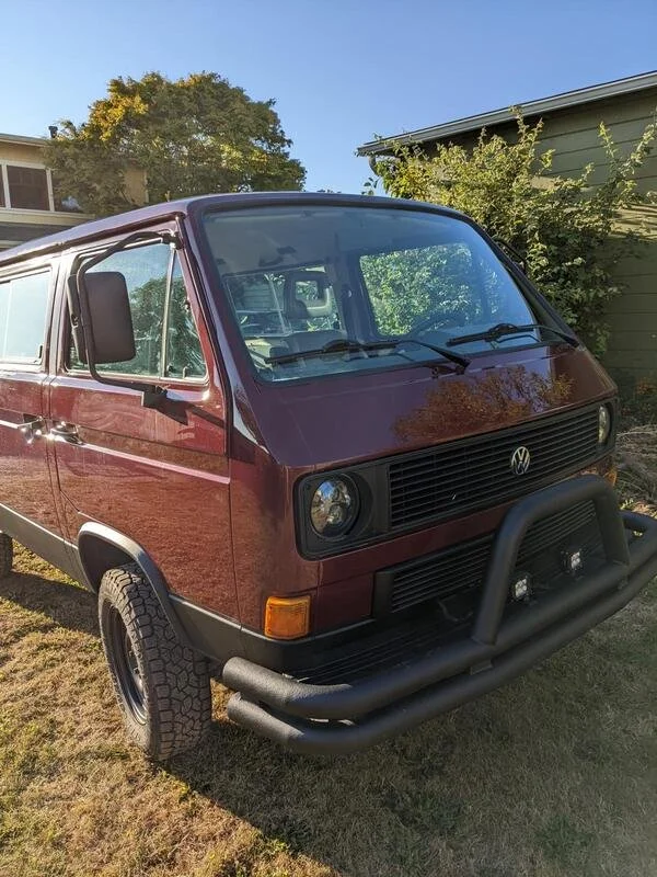 Burgundy Volkswagen van viewed from the front on a lawn