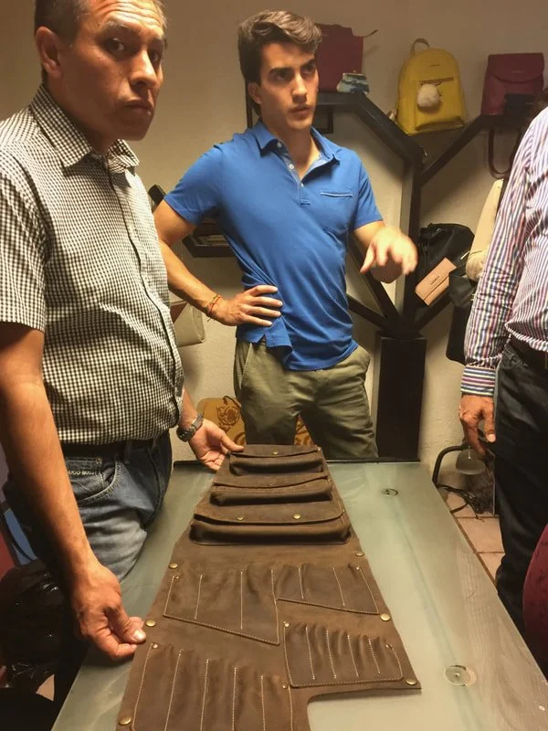 Examining a leather Westy Bravo prototype on a table