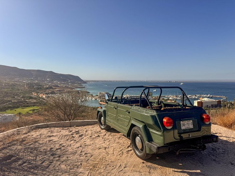 Green Volkswagen Thing overlooking the coast