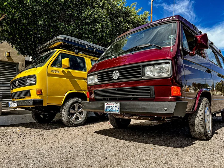 Different front-bumper and wheel combinations on two equipped Vanagons.