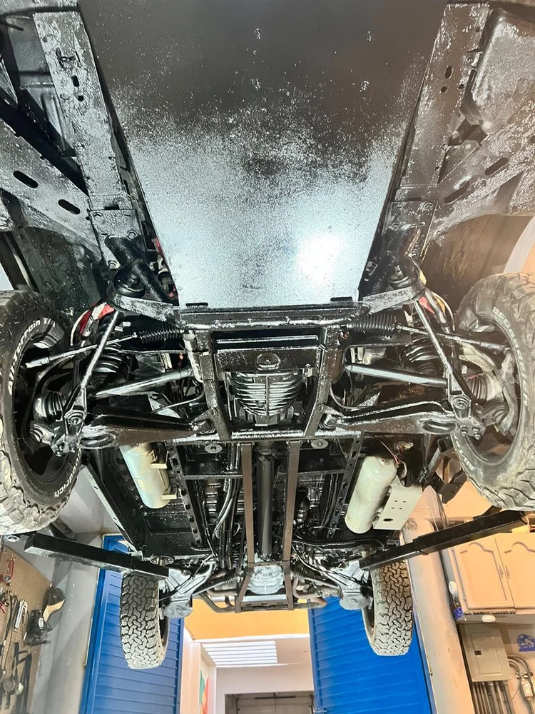 A view beneath a restored van, showing the suspension and driveline together.