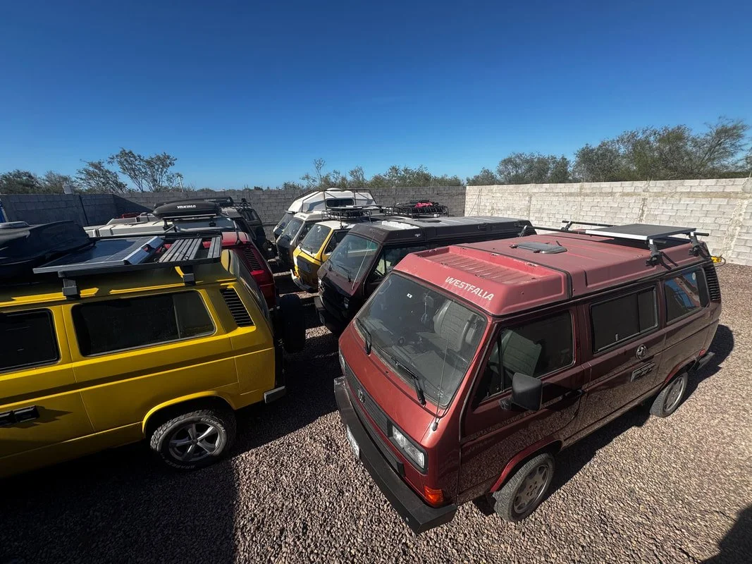 Vans Volkswagen estacionadas en el área de resguardo al aire libre, dentro de un terreno amurallado en La Paz