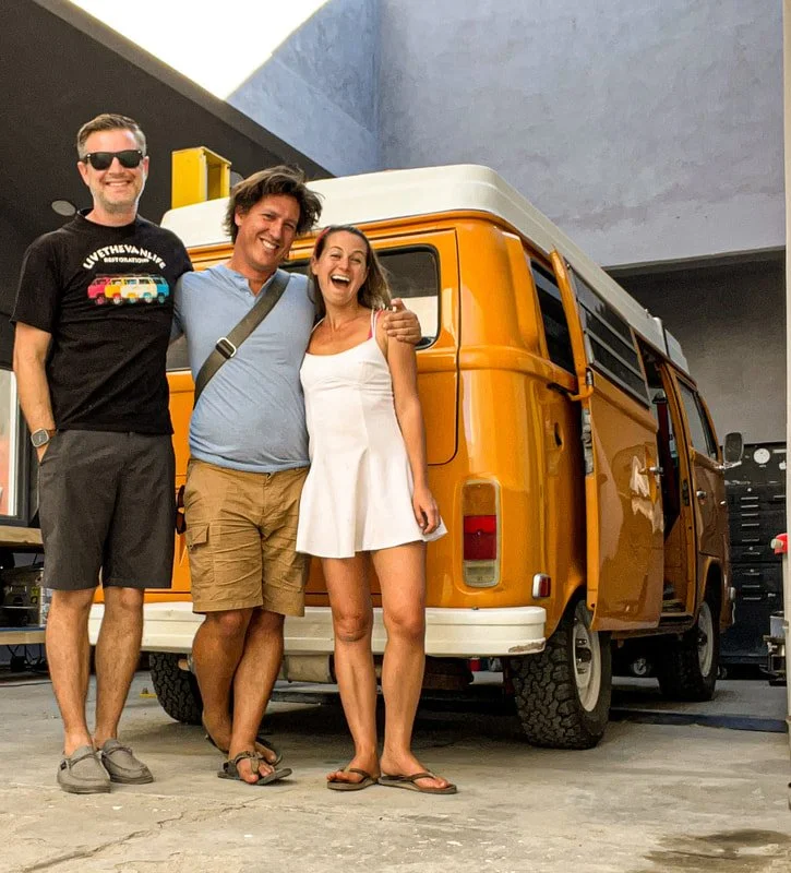 Three people beside a yellow Volkswagen Bus
