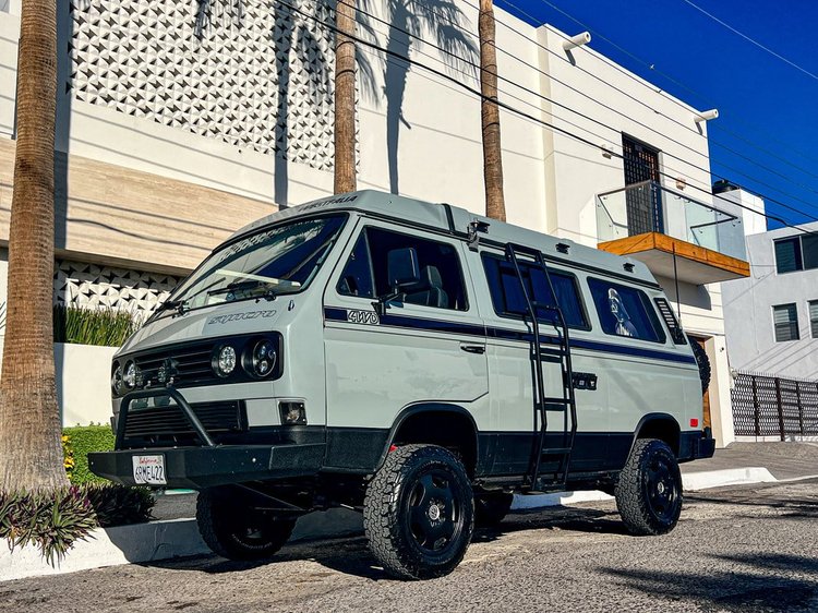 Pale green Volkswagen Vanagon with black wheels parked outside