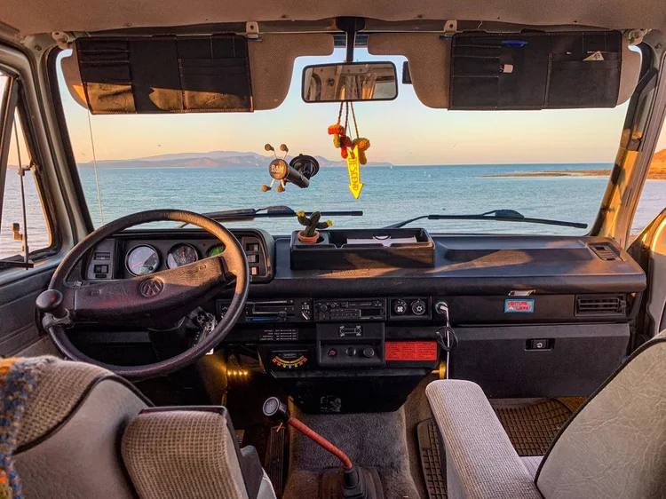 Camper van dashboard and front seats overlooking the sea