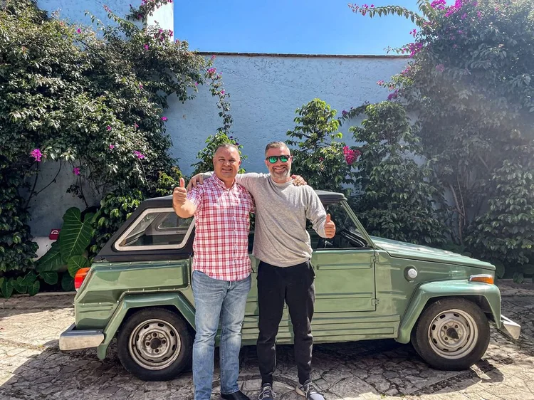 Two people beside a green Volkswagen Thing