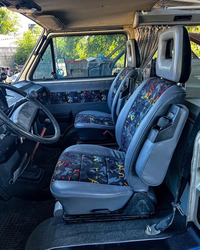 Blue upholstered front seats and dashboard inside a Volkswagen van
