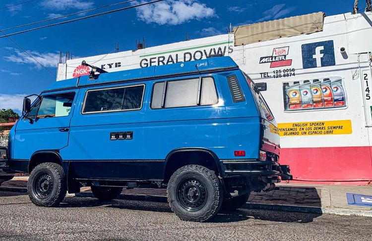 Blue Volkswagen camper outside a workshop