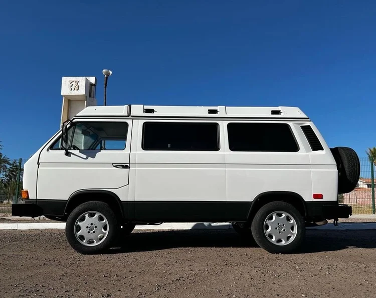 White high-roof Volkswagen camper in profile