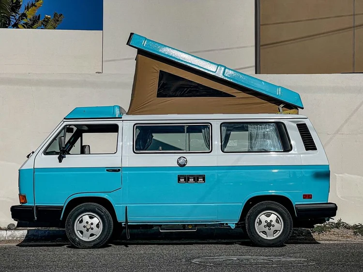 Turquoise-and-white Volkswagen Westfalia with raised pop-top