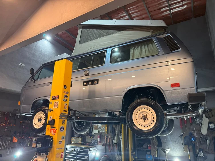 Silver Volkswagen Vanagon raised on the workshop lift
