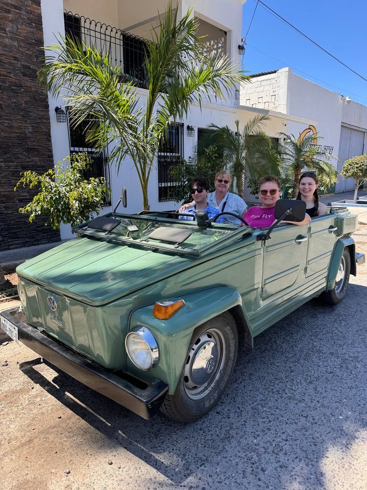 People seated in a green Volkswagen Thing