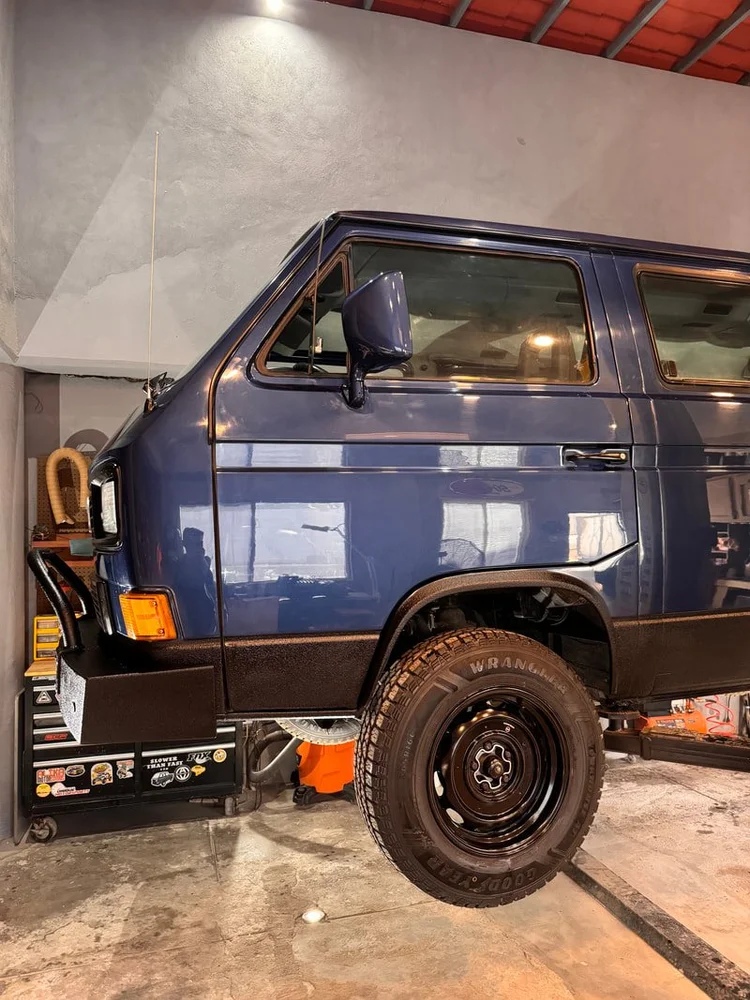 Blue Volkswagen Vanagon with black wheels in the workshop