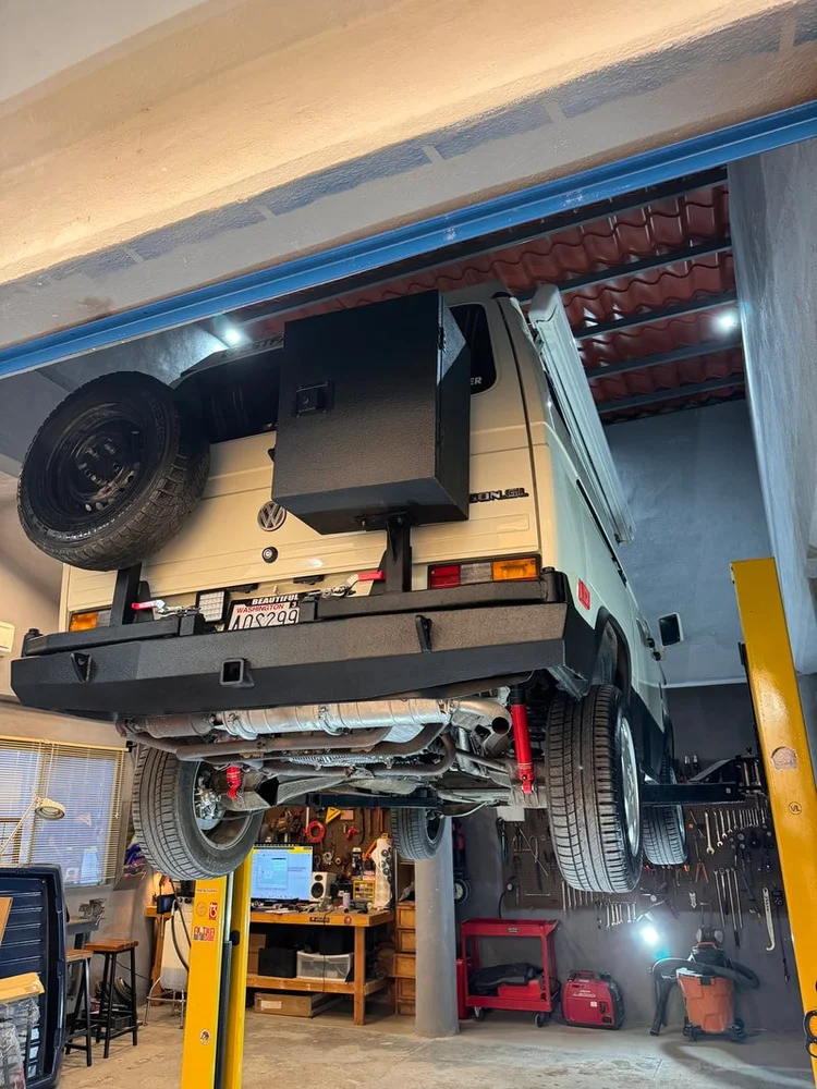Rear underside of a camper van raised above the workshop floor