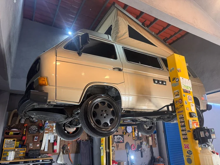 Cream Volkswagen Westfalia with raised pop-top on a lift