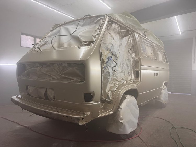 Volkswagen van masked for spraying inside the paint booth