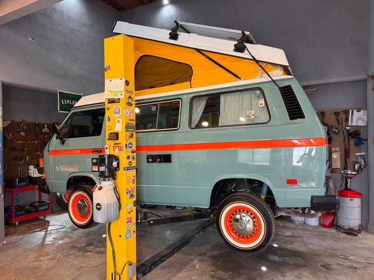 Gray Volkswagen Westfalia with orange stripe and raised pop-top