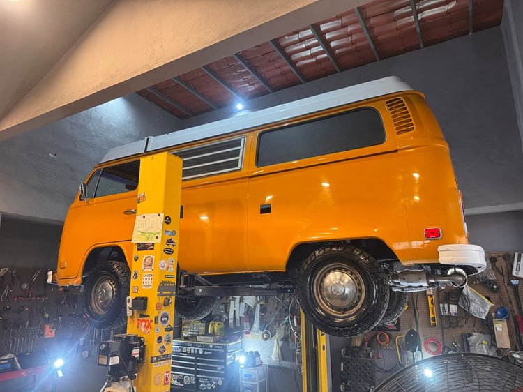Orange Volkswagen Bus on a workshop lift