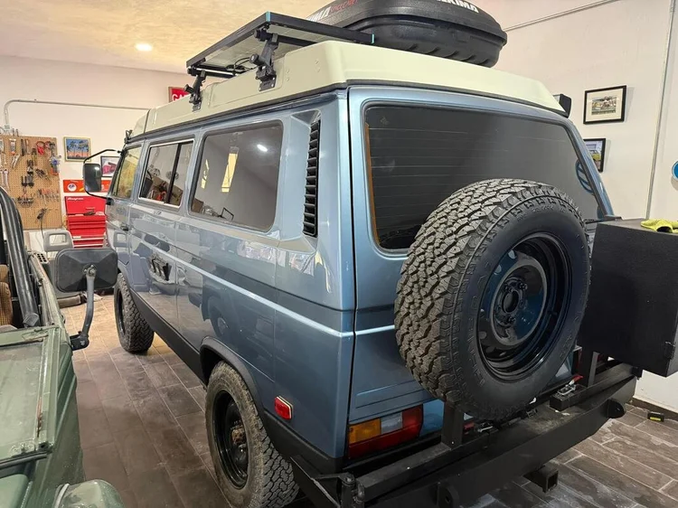 Rear view of a blue Volkswagen camper with spare wheel carrier