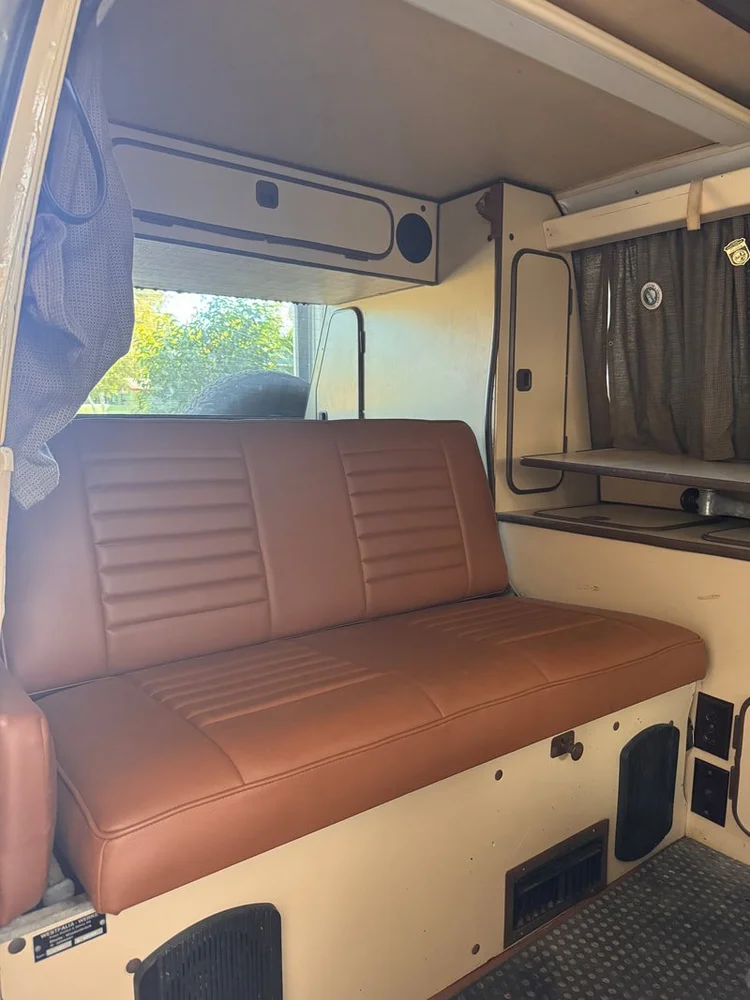 Brown rear bench seat and cabinets inside a Volkswagen camper