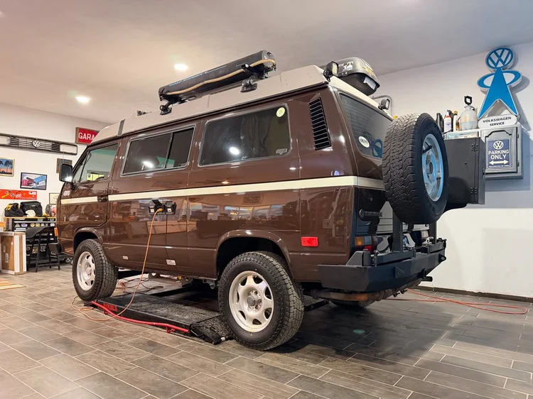 Brown Volkswagen camper with roof accessories and rear spare wheel