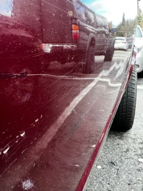 Low-angle view along the lower side of a burgundy Volkswagen van