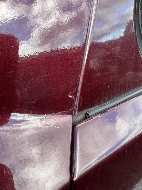 Close-up of burgundy Volkswagen body seams and lower trim