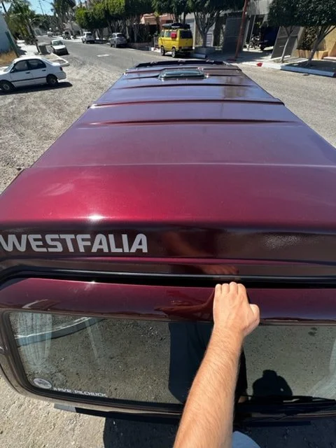View across the roof of a burgundy Volkswagen Westfalia