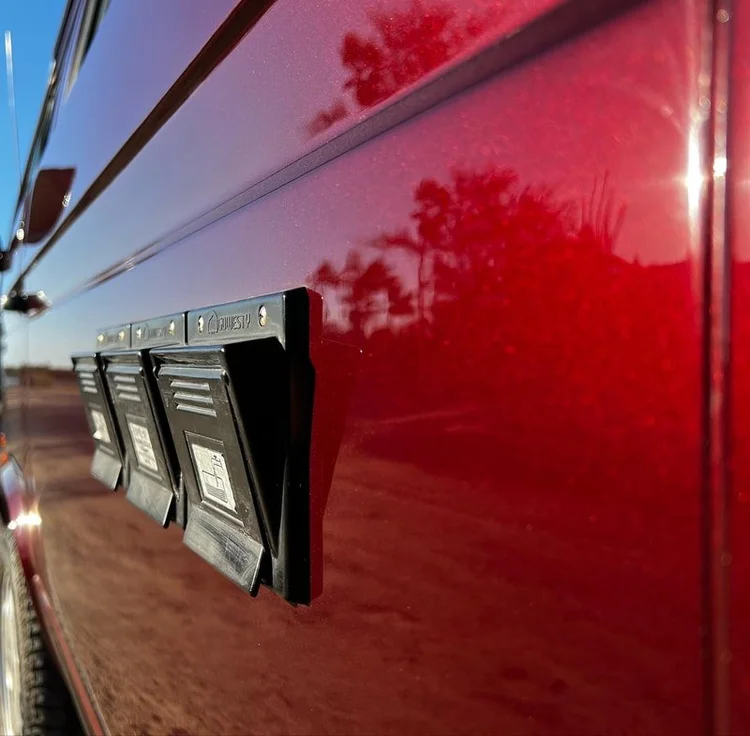 Close-up of a sliding door handle on a burgundy Volkswagen van