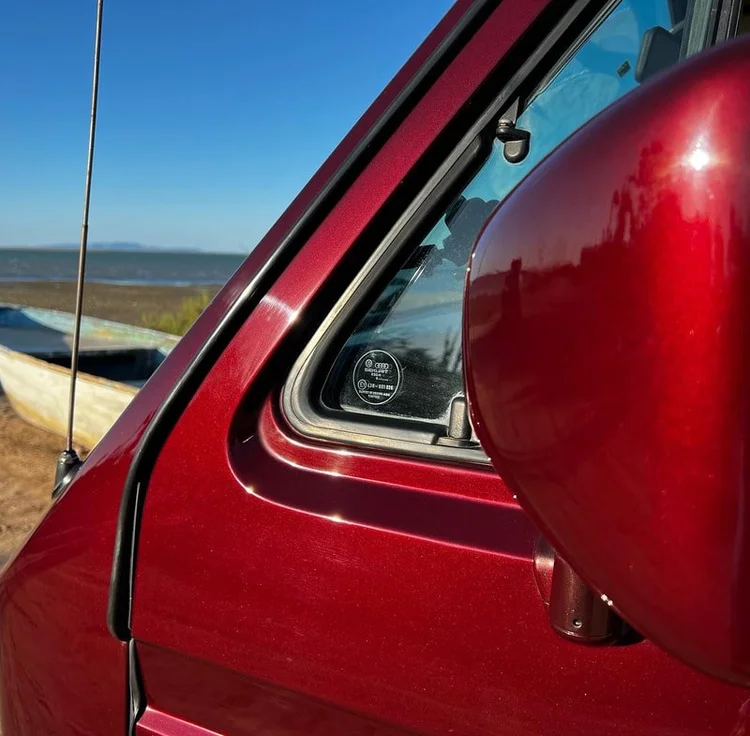 Burgundy Volkswagen side mirror and front quarter window