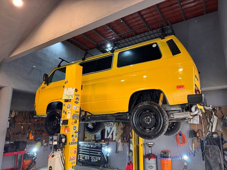 Yellow Volkswagen Vanagon on a workshop lift
