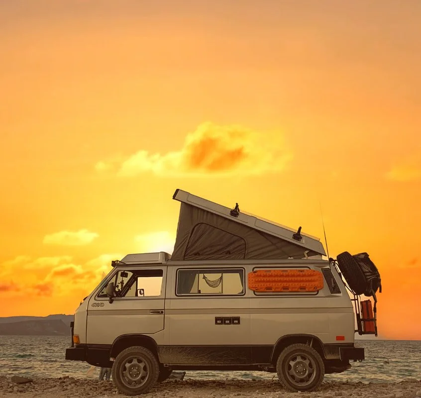 Miki with the pop-top raised beside the sea at sunset