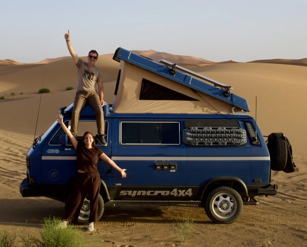 Our blue Volkswagen Syncro Westfalia with its pop-top raised among Sahara Desert dunes in Africa