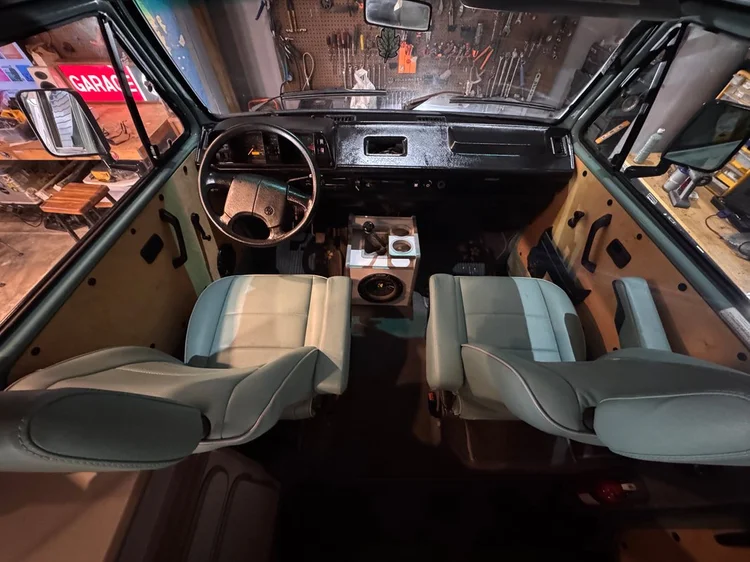 Volkswagen camper cab viewed from behind light-colored front seats