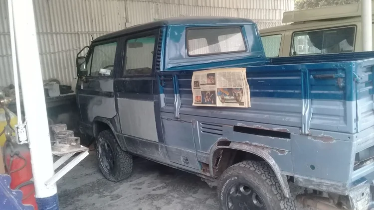 Blue Volkswagen double-cab pickup with areas of bodywork in progress