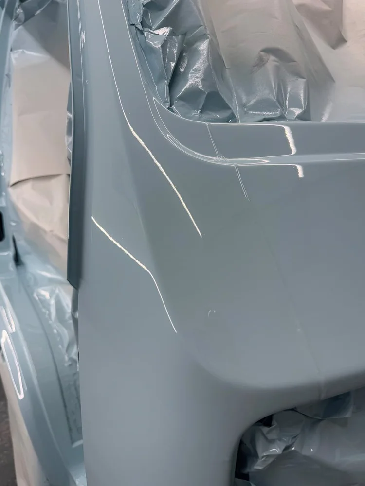 Close-up of a painted light blue Volkswagen body panel