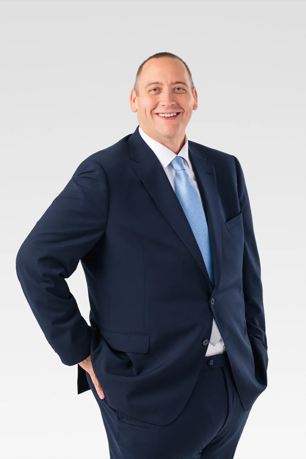 Jamie Selzler standing in a navy suit