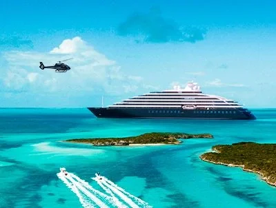 Luxury small cruise ship in turquoise waters beside tropical islands
