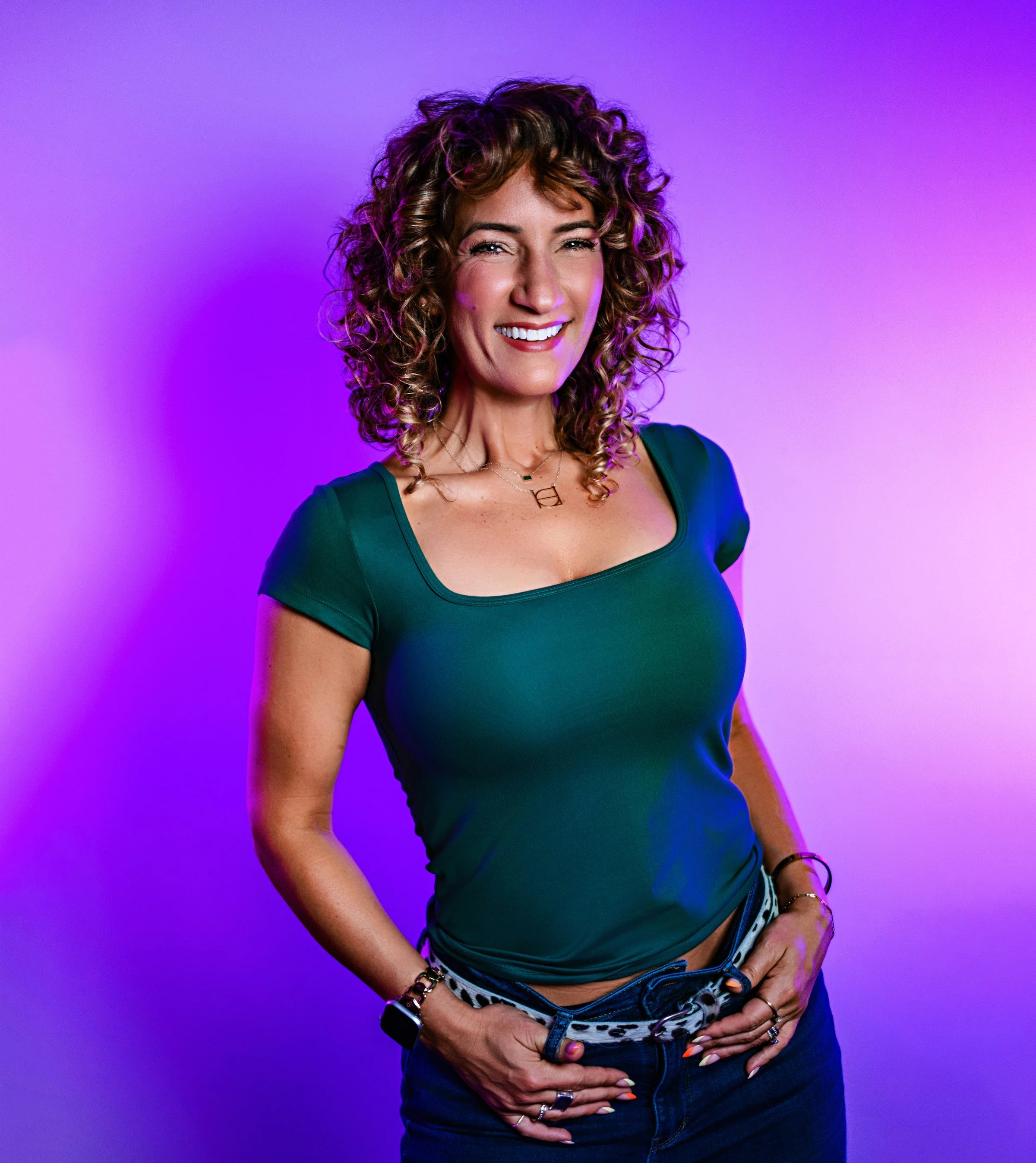 Laya Hoffman smiling in an emerald top against a purple background.