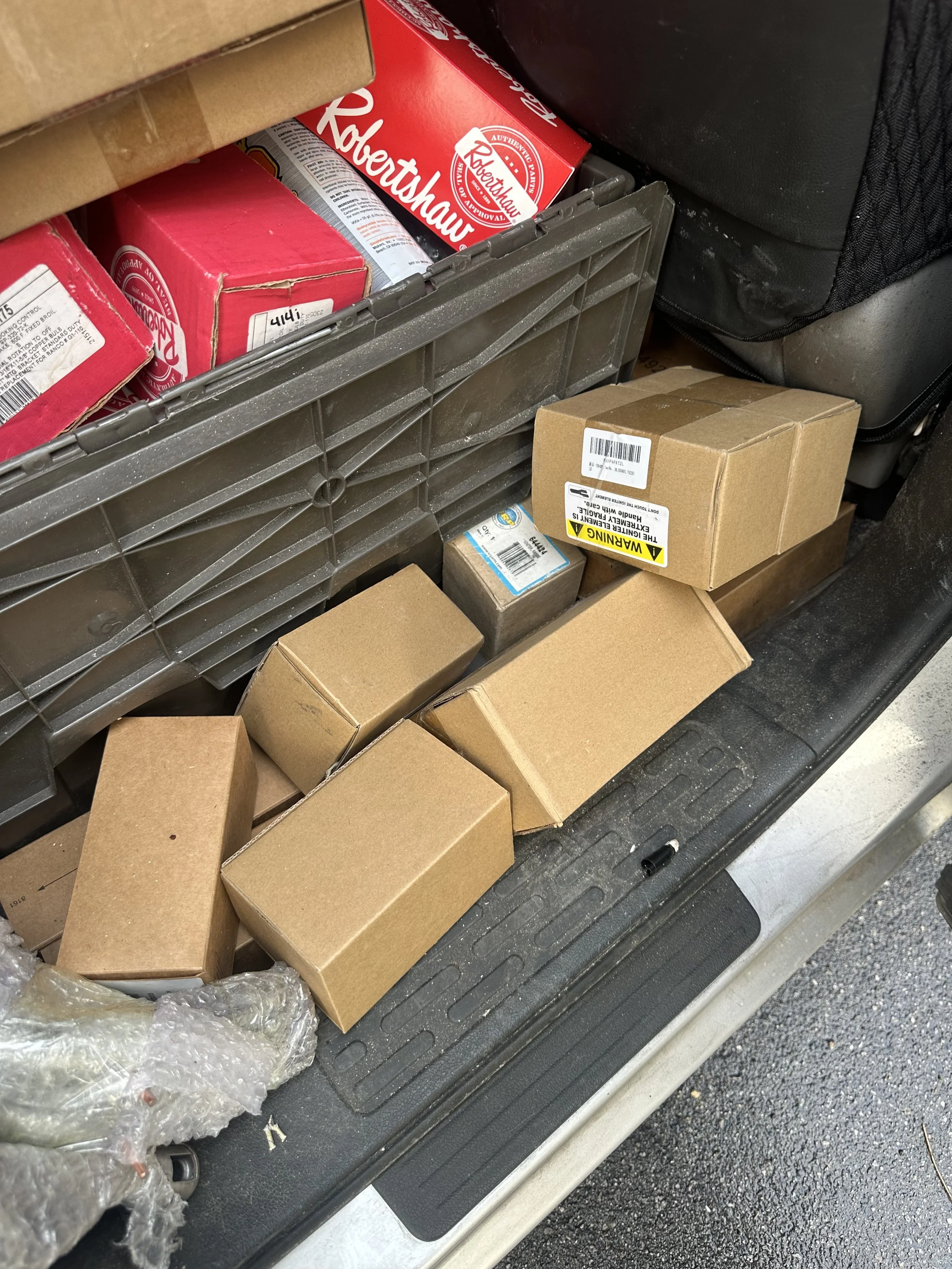 Organized OEM appliance replacement parts and Robertshaw components ready for field repair