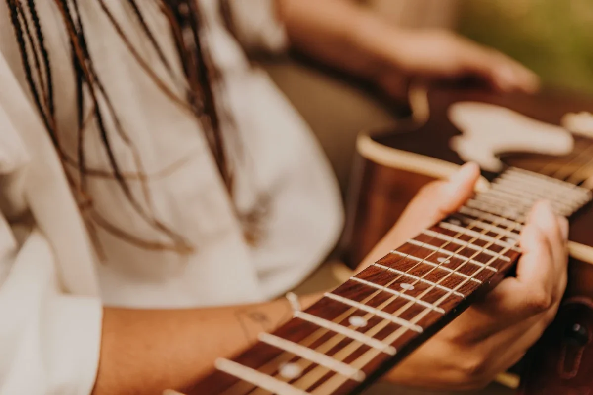 Detail of Mye's hands on the guitar fretboard