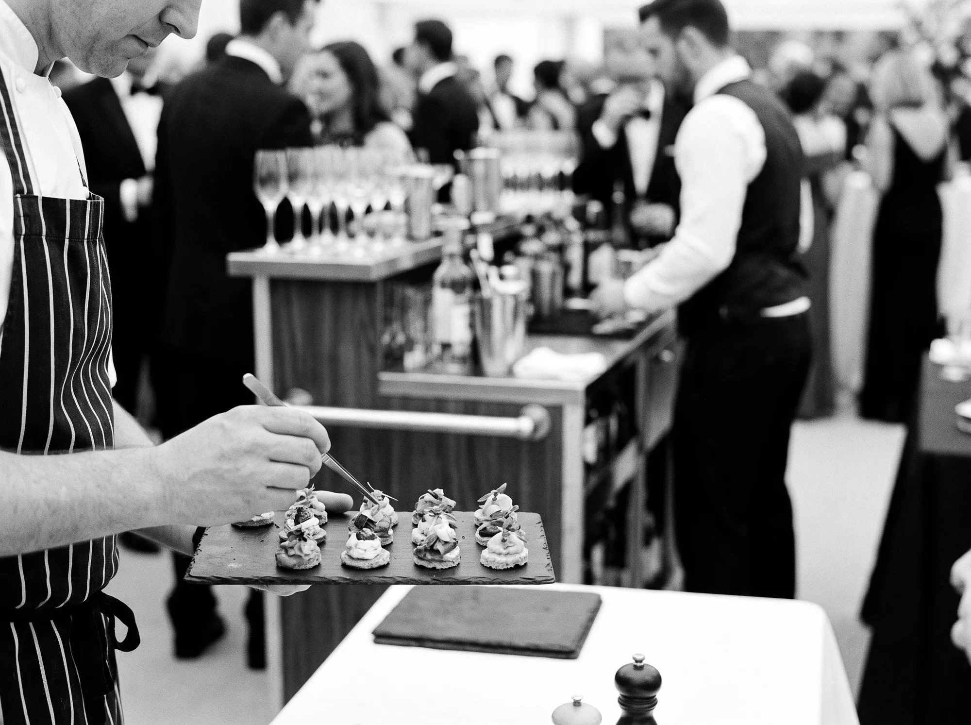 A chef preparing canapés beside an event bar