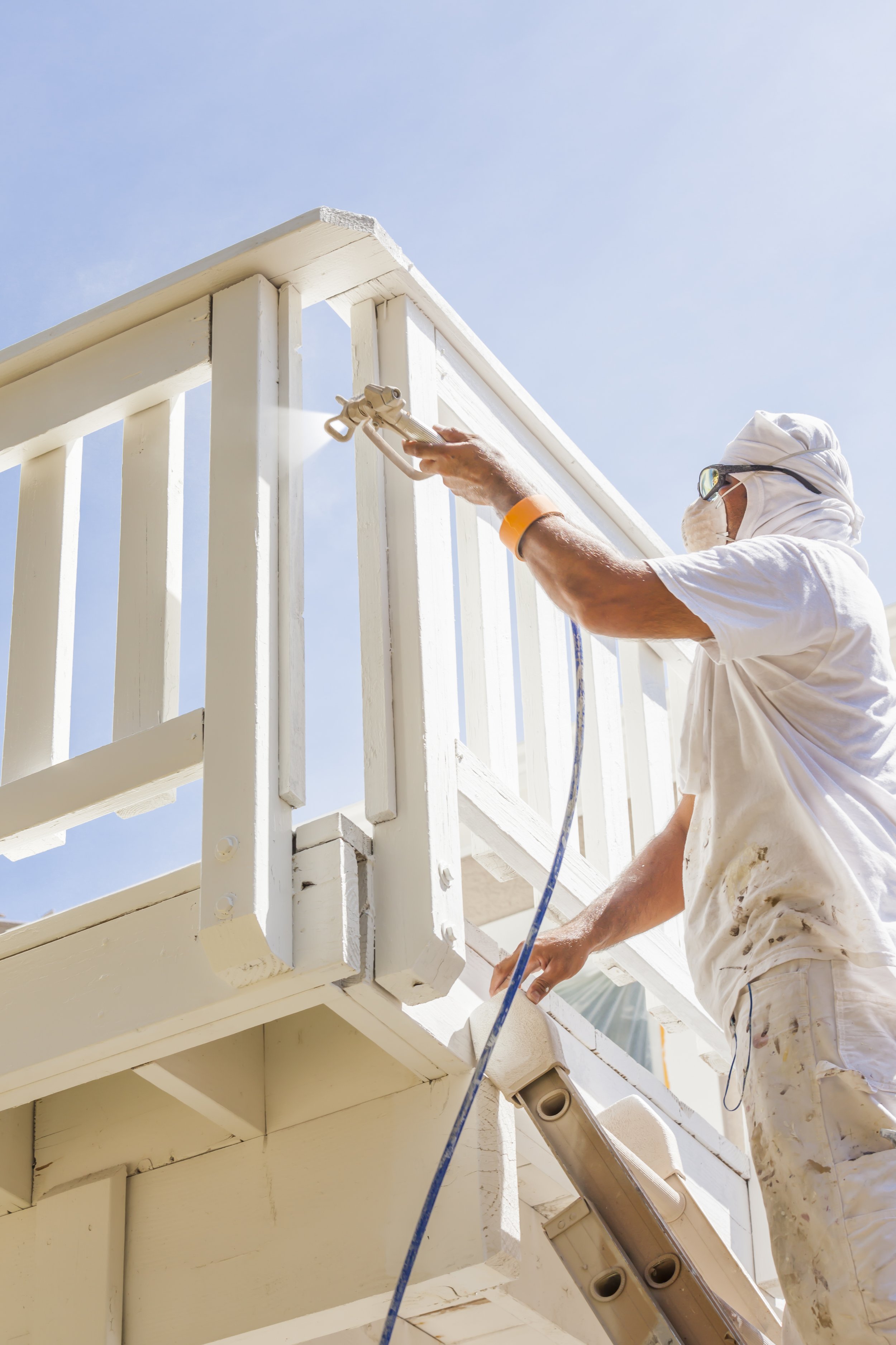 Painter spraying exterior railing