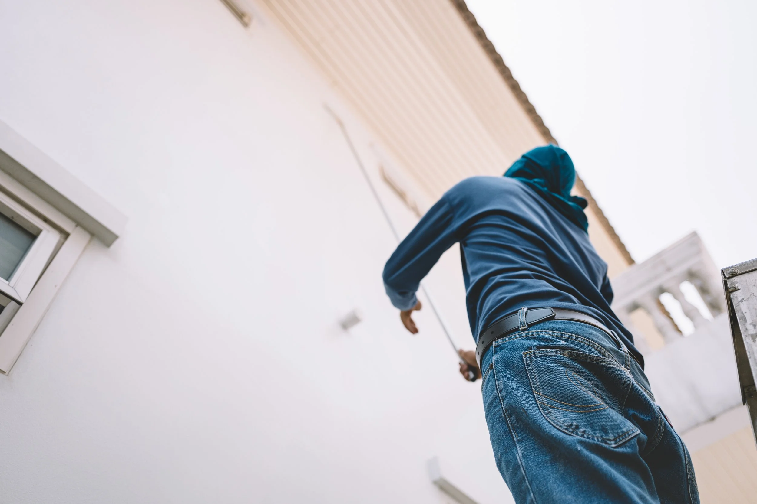 Painter rolling a building exterior