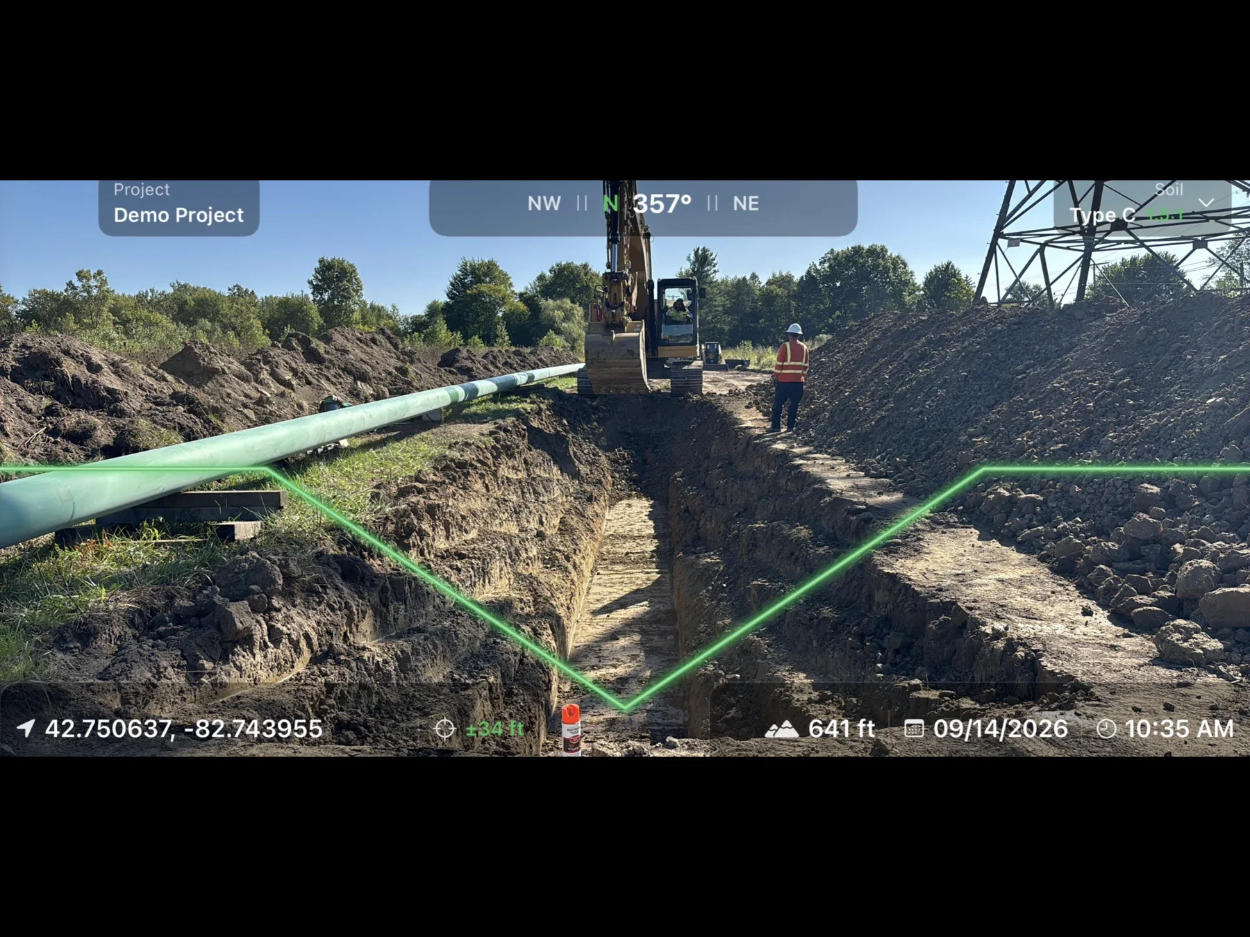 Field Forged Excavation camera view of an open trench with a green slope overlay, location, compass heading, date and time stamped on the photo