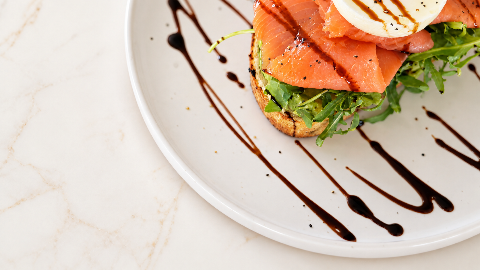 Le Brulée Café avocado toast topped with smoked salmon and egg