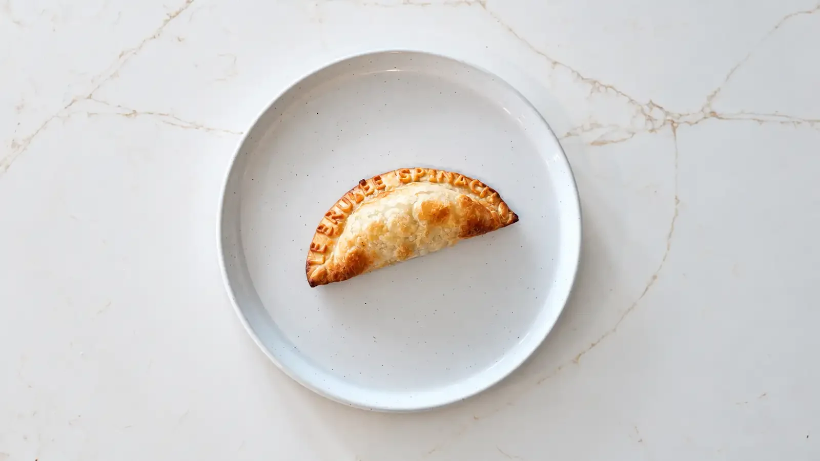 Le Brulée Café spinach empanada on a white plate