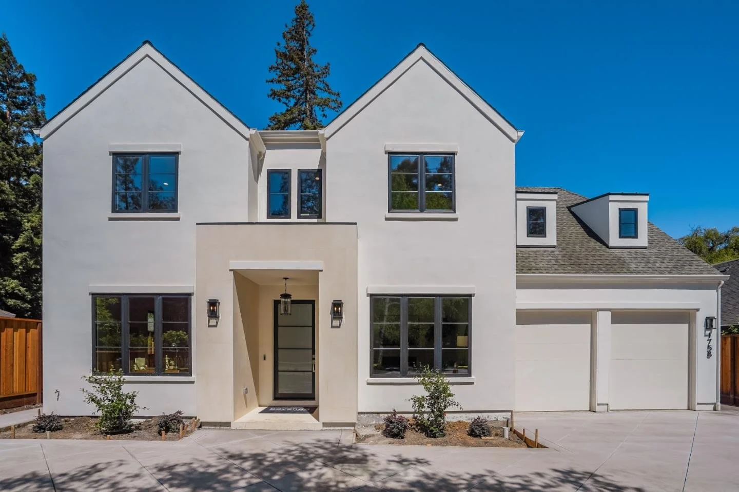 Illustrative white modern home with twin gables and black-framed windows