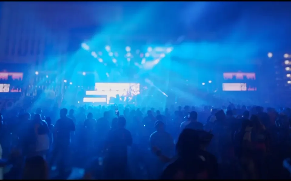 A concert crowd under blue stage lights