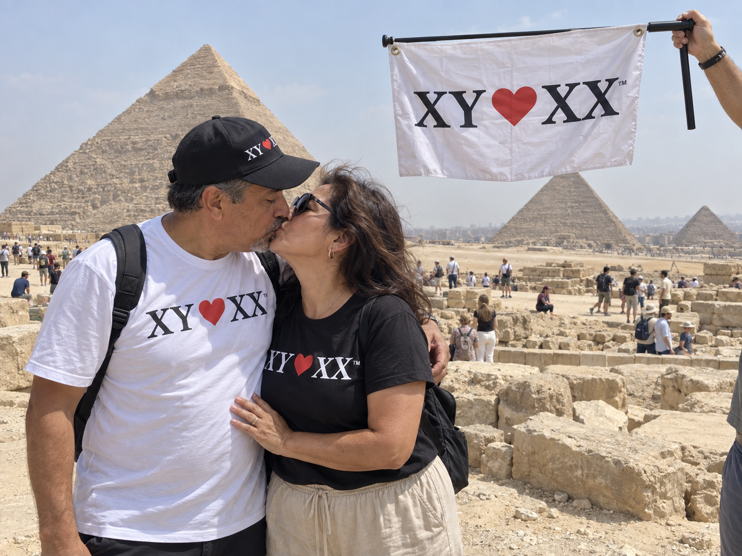 Couple sharing a kiss near the pyramids with a hanging TSF flag.